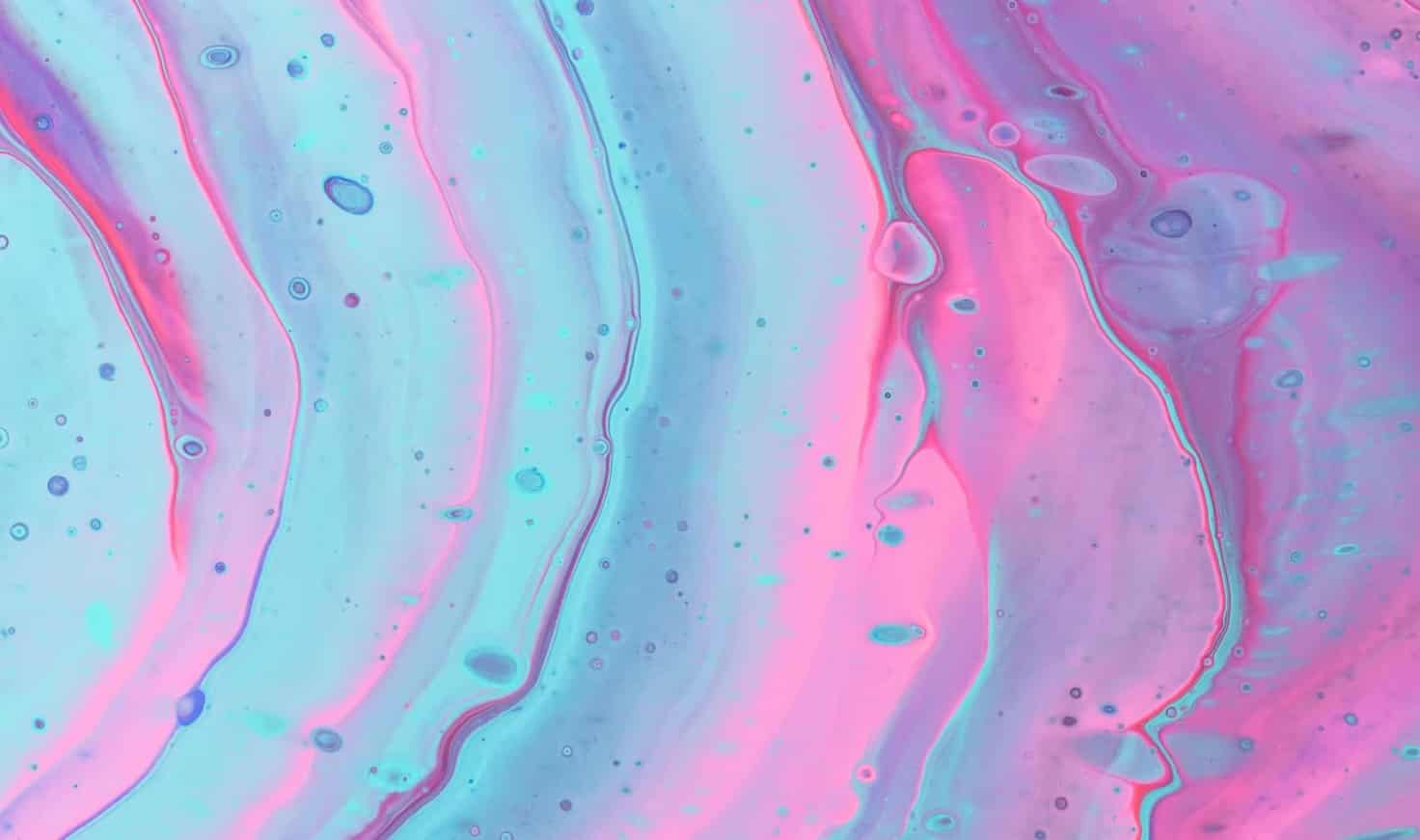 Ondas iridiscentes de un líquido azul brillante y rosa